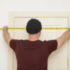 Man With Hat Measures Door Frame